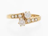 a close up of a gold ring with three white diamonds