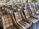 Plusieurs fauteuils en cuir marron sont alignés en rangée dans une salle d'attente
