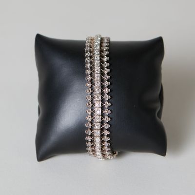 un oreiller noir sur lequel sont posés deux bracelets