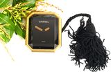 a black watch and a black tassel next to a bouquet of flowers
