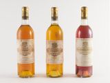 three bottles of wine sitting next to each other on a white surface