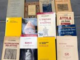 Plusieurs livres sont empilés les uns sur les autres par terre.