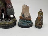 three figurines of a man and a woman on a boat