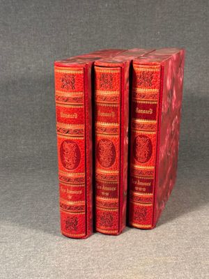 three red books sitting on top of each other on a table
