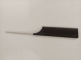 a black comb with a white handle on a white surface