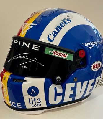 casque dédicacé d'un pilote de course exposé sur un fond blanc