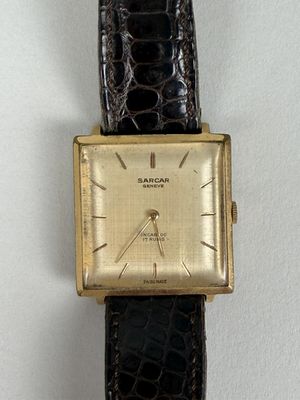 a close up of a watch on a white surface