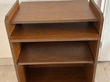 a wooden book shelf with three shelves on top of it