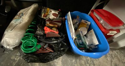 a blue plastic container filled with assorted items on the floor