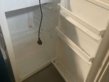 a white refrigerator with its door open in a room