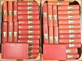 de nombreux livres rouges dans un coffret en bois posé sur une table
