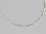 a white pearl beaded necklace on a gray background