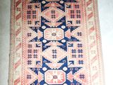 un vieux tapis orné d'un motif bleu et rose
