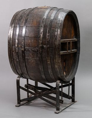 an old wooden barrel sitting on top of a metal stand