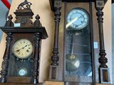 two clocks that are sitting on a wooden table