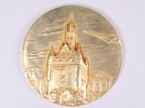 une médaille d'or sur laquelle est représenté un château