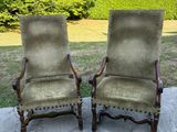 une paire de chaises rembourrées anciennes sur une terrasse en pierre, avec des arbres en arrière-plan