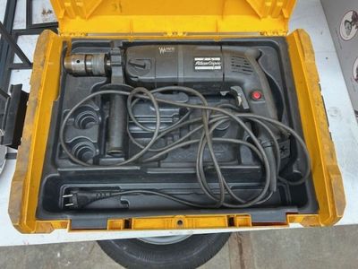 Une perceuse filaire, dans sa boite