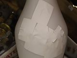 a white vase with a piece of paper taped to it