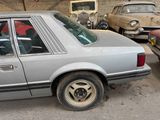 a car that is parked in a garage with other cars in the background