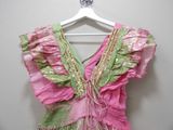a pink and green dress hanging on a hanger
