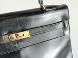 a close up of a black leather handbag with gold hardware