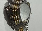 a silver and gold watch on a white surface