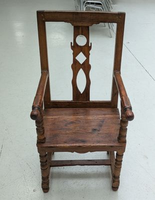 a wooden chair that has a mirror on the back of it