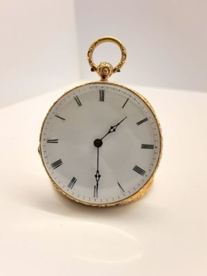 une montre de poche en or avec des chiffres romains sur le cadran