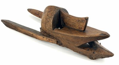 an old wooden clamp with a piece of wood sticking out of it