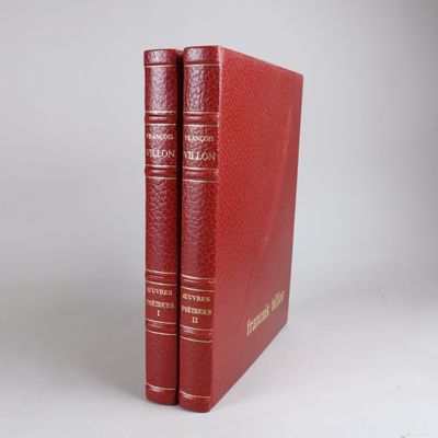 two red books sitting on top of each other on a white surface
