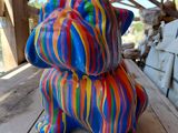une statue colorée représentant un chien assis sur une table en bois