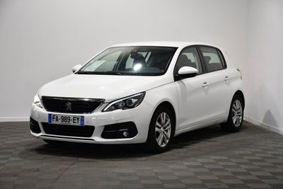 the small white car is parked in a room with a checkered floor