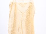a white top with a lace trim on it hanging on a hanger