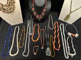 several necklaces and bracelets are displayed on a black table
