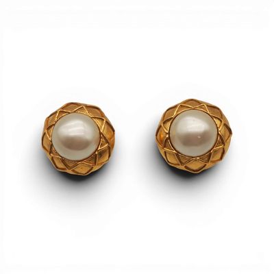 une paire de boucles d'oreilles en or et perles sur fond blanc