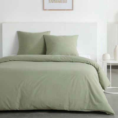 un gros plan sur un lit avec une couette et des oreillers verts