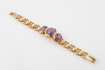 a gold bracelet with amethtites and purple stones
