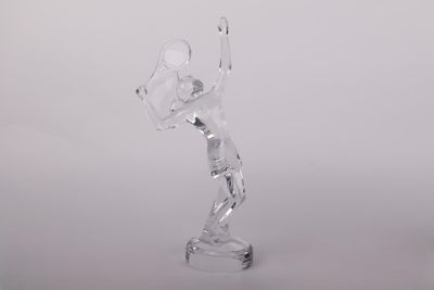 figurine en verre transparent représentant une femme tenant une raquette de tennis