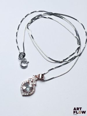 une chaîne en argent avec un pendentif orné d'une topaze bleue