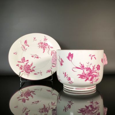 a pink and white cup and saucer sitting on a table