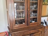 un vaisselier en bois avec des portes en verre dans une pièce