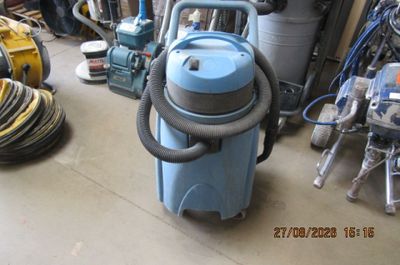 un aspirateur bleu posé par terre