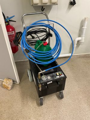 une photo d'une pièce où se trouvent un extincteur et des tuyaux d'arrosage
