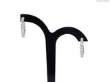 pair of diamond hoop earrings on a black stand on a white background