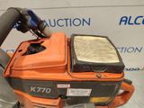 an orange and black gas powered chainsaw sitting on top of a table