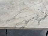 a marble table with cast iron legs and a marble top