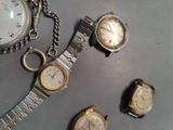 three watches on a table with a chain around them