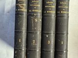 quatre vieux livres sont alignés sur une surface blanche