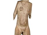 une vieille statue en bois d'un homme avec un chapeau sur la tête